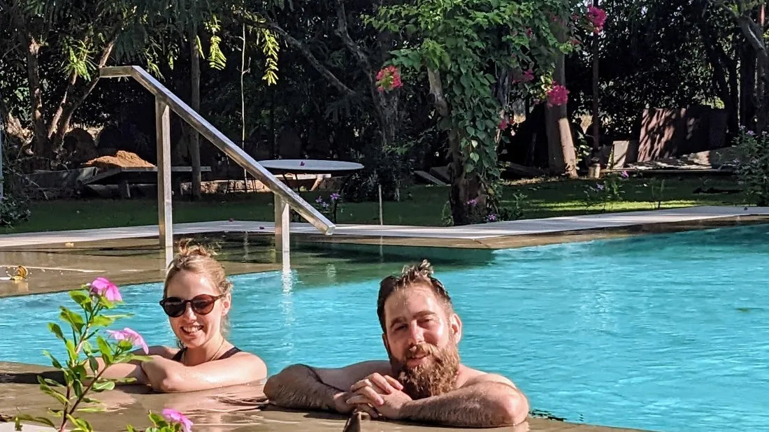 Two guests relaxing together at the edge of the pool