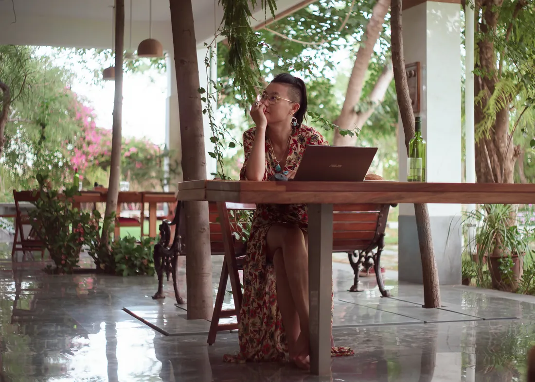 Guest working on a laptop at an outdoor table on the farm