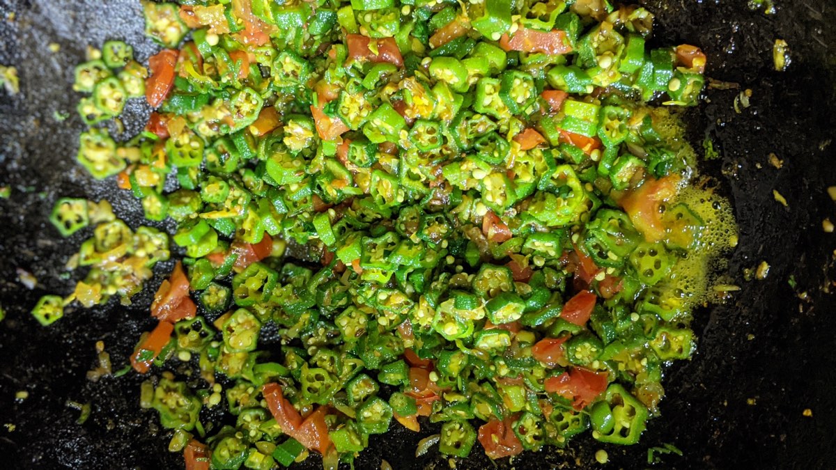 Okra and tomato cooking in the pan