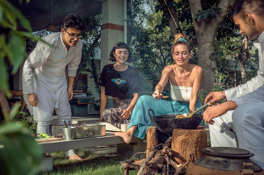 Udai and the team cooking with guests over a chulha