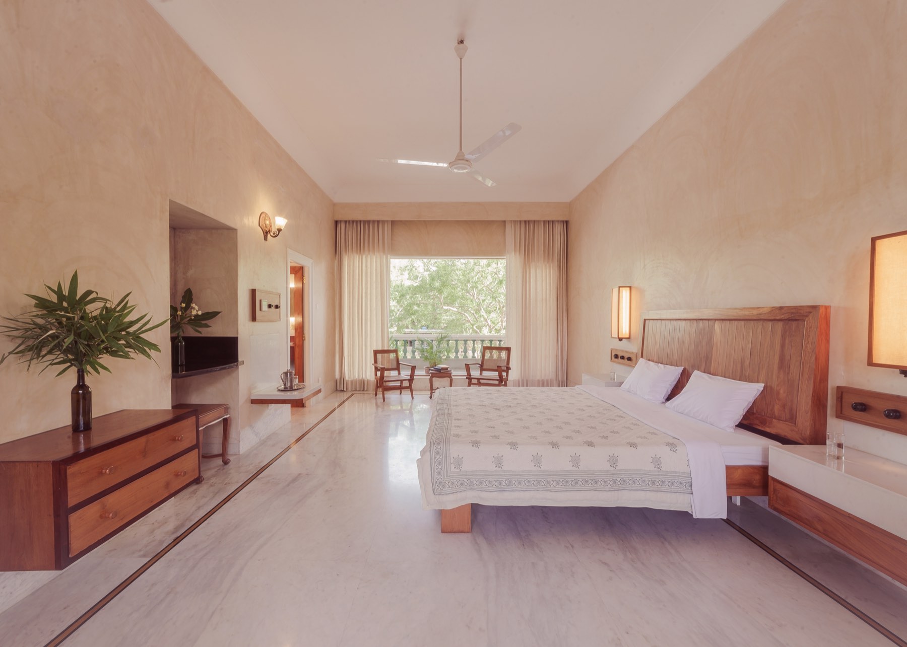 The Deluxe room — bed, desk, sitting area, and the garden window