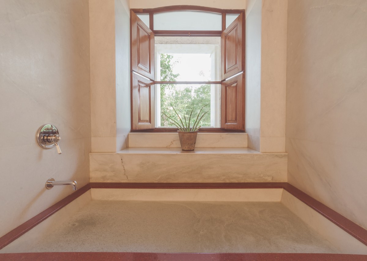 The Deluxe bathroom — marble tub beside the window