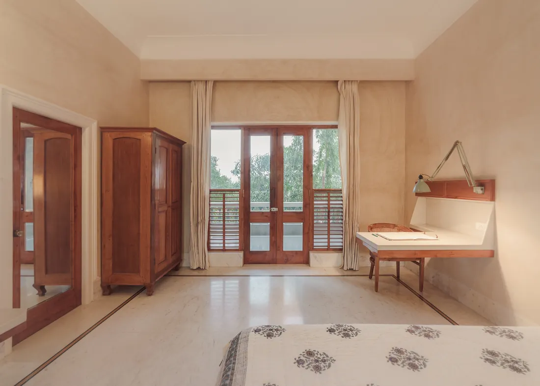 Antique wardrobe, balcony doors, and marble desk in the Deluxe room