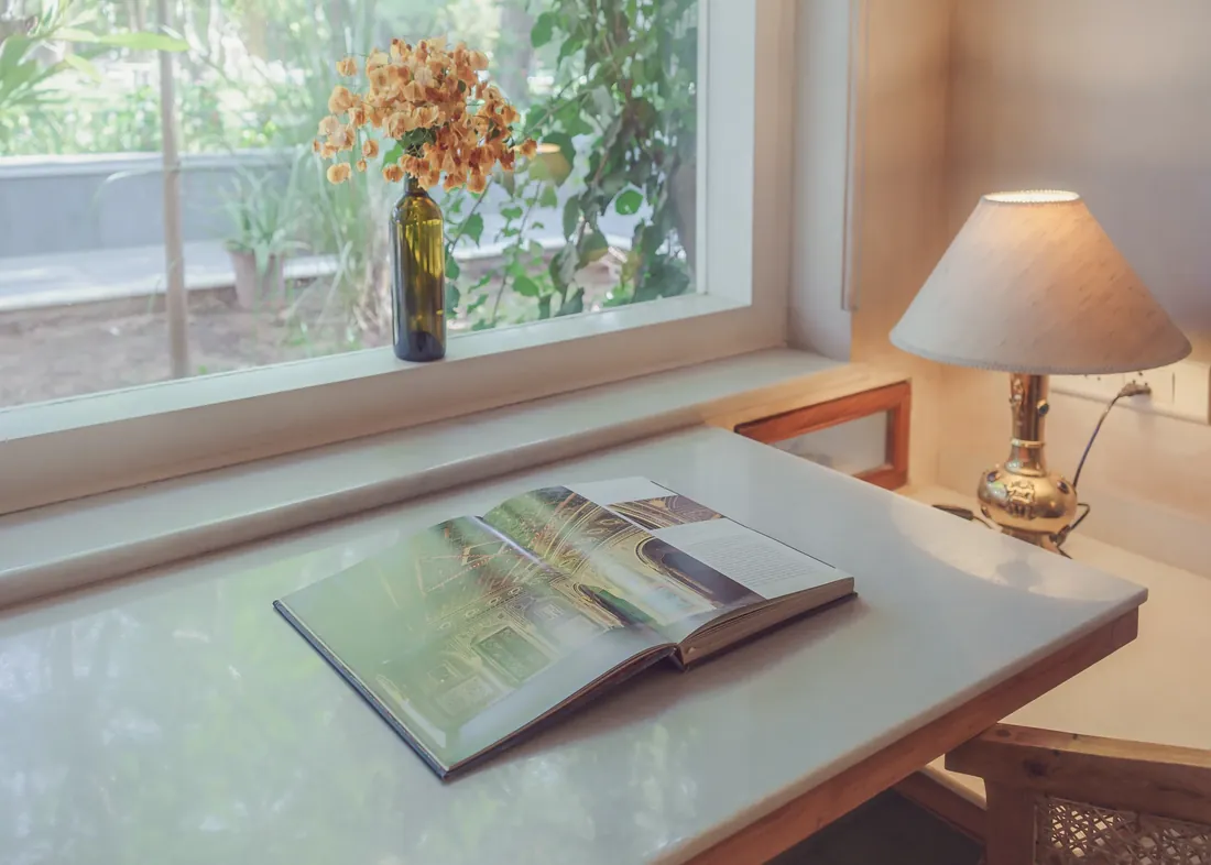 The marble desk beside a garden window, with a reading light
